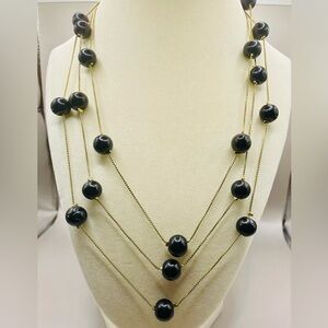 60 inch gold tone necklace with black bead stations. Can be doubled or tripled.